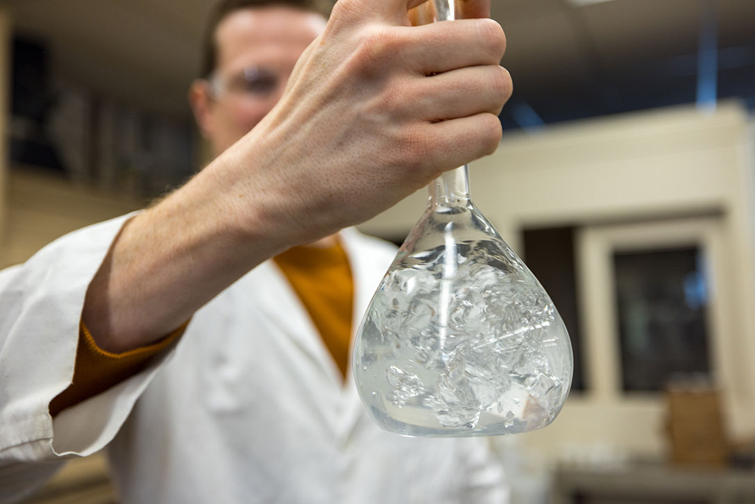 Man in lab with glassware - Calcium Chloride 83-87% Granulated - OxyChem