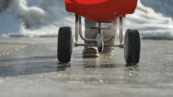 OxyChem PELADOW Calcium Chloride being spread on a icy sidewalk