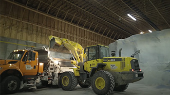 Front-end loader filling a snowplow truck with OxyChem LIQUIDOW Calcium Chloride